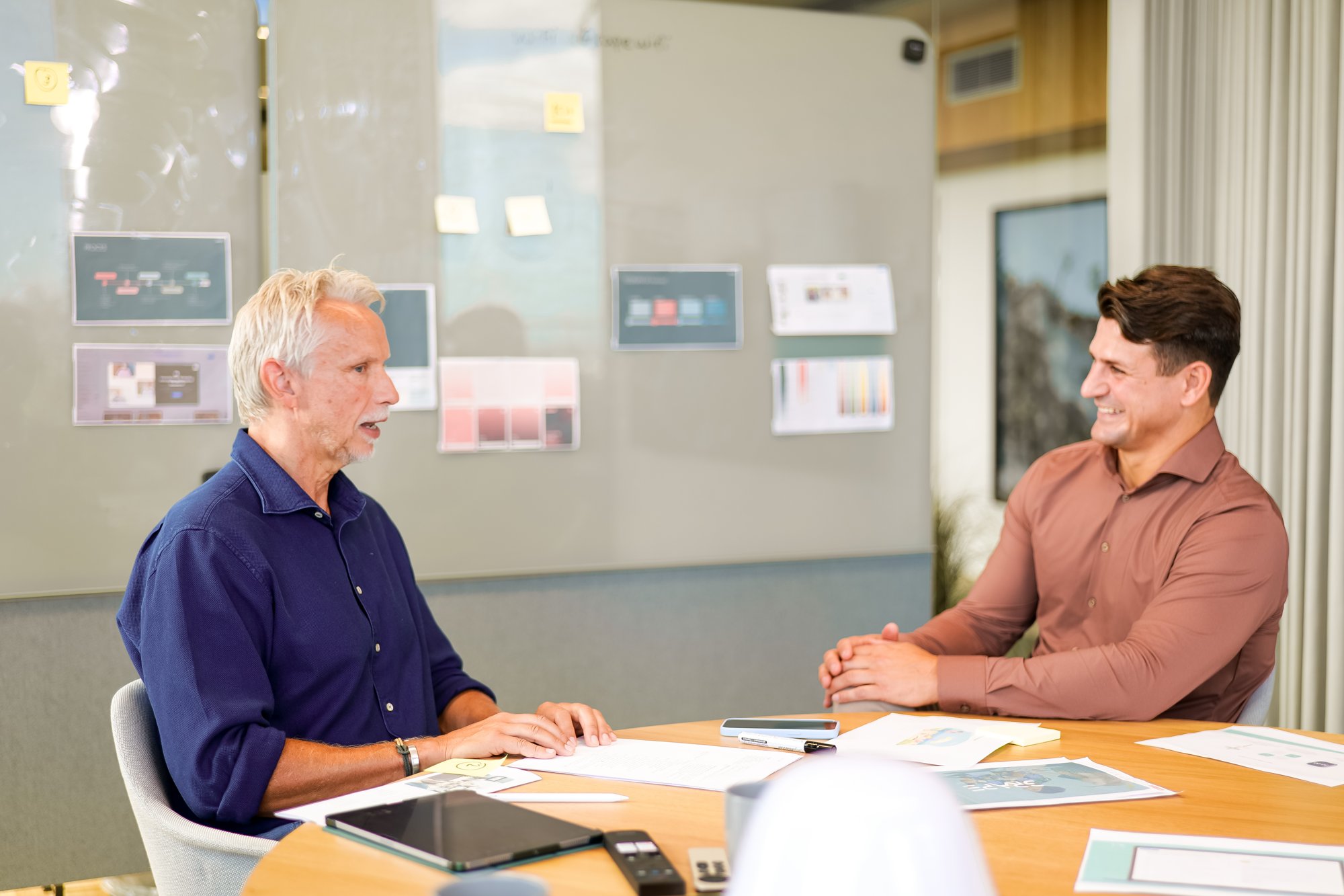 Two Harvest consultants in conversation at a meeting table